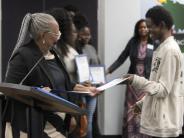 Rep. Yvonne Hayes Hinson presents a certificate to a teen